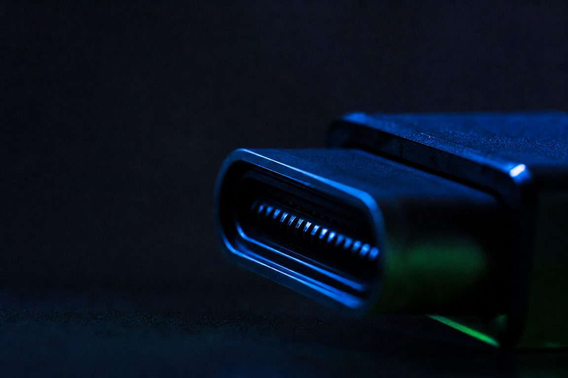 A device docking connector in macro, pins catching a blue rim light