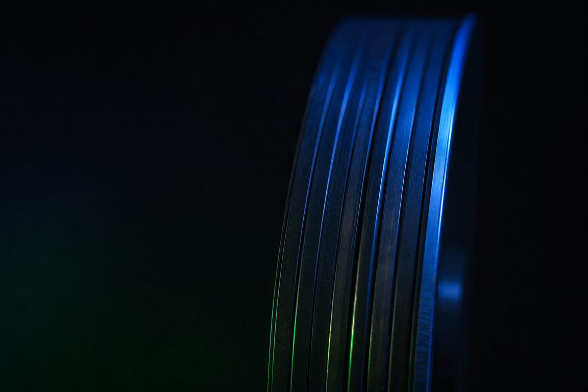 A vertical stack of thin brushed-metal discs seen edge-on