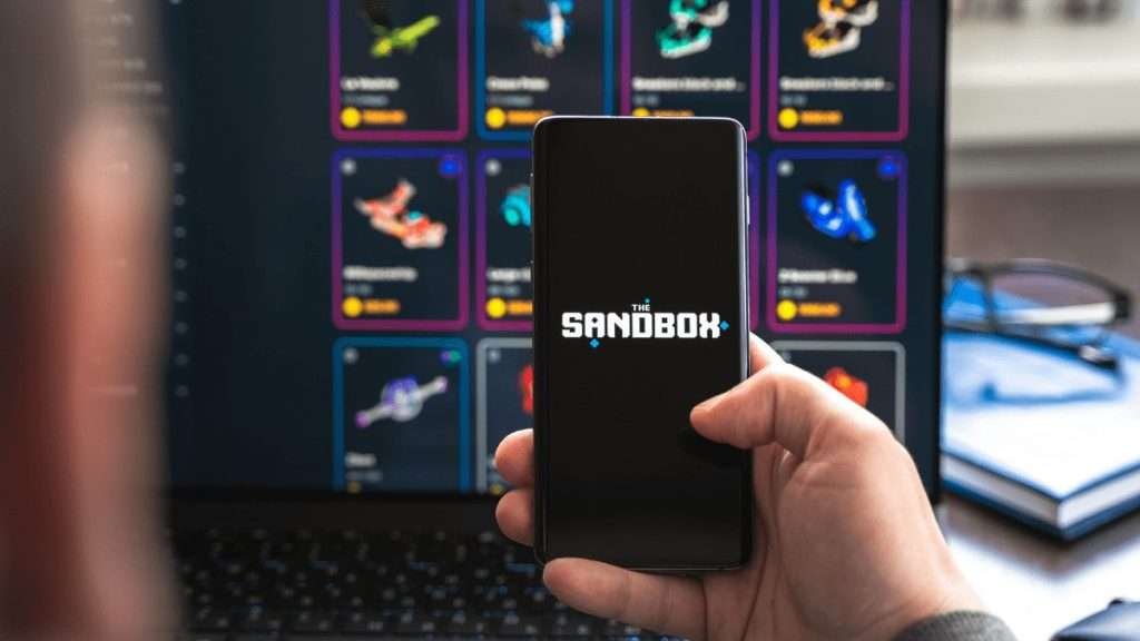 sandbox viewed by a man in his phone sandbox price prediction