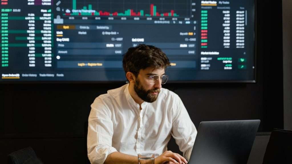 man is checking curve price and its chart using laptop